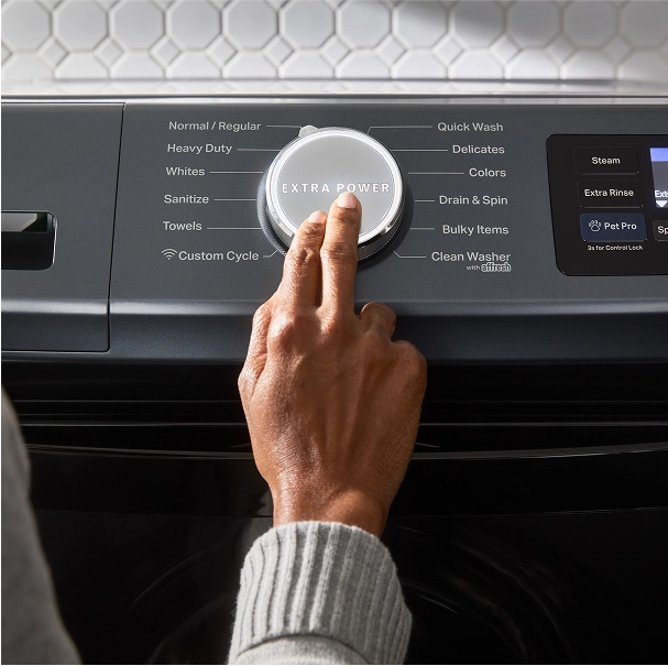 A person selecting Extra Power on a washing machine