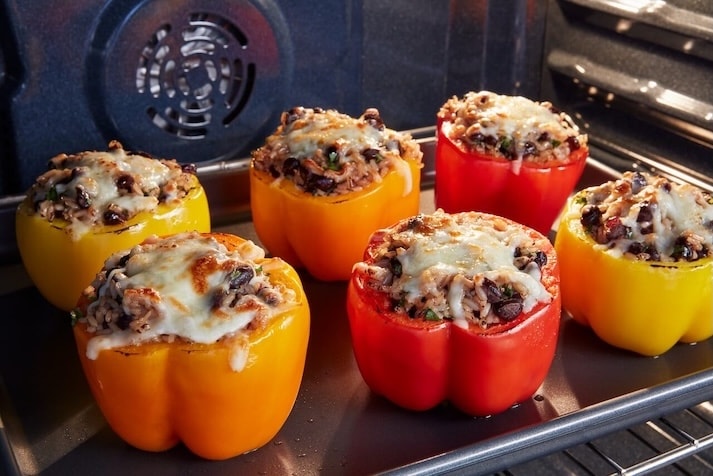 Stuffed peppers cooking inside of a Maytag® range.