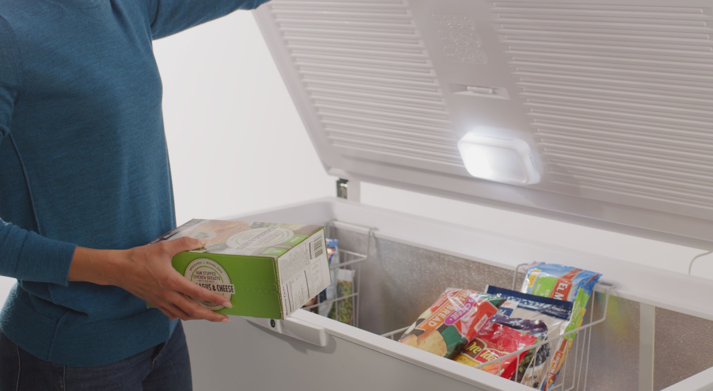 Person placing food in a freezer Person placing food in a freezer