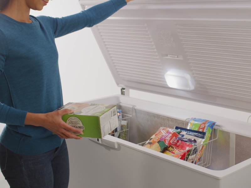 Person placing food in a freezer Person placing food in a freezer