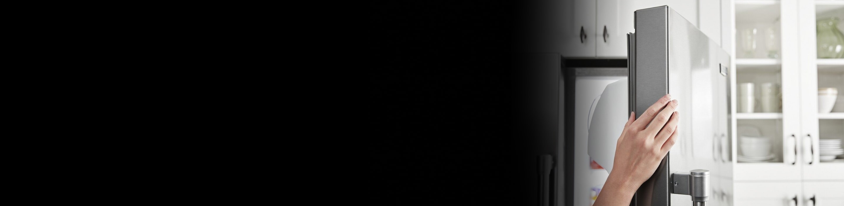 A hand opens a refrigerator door