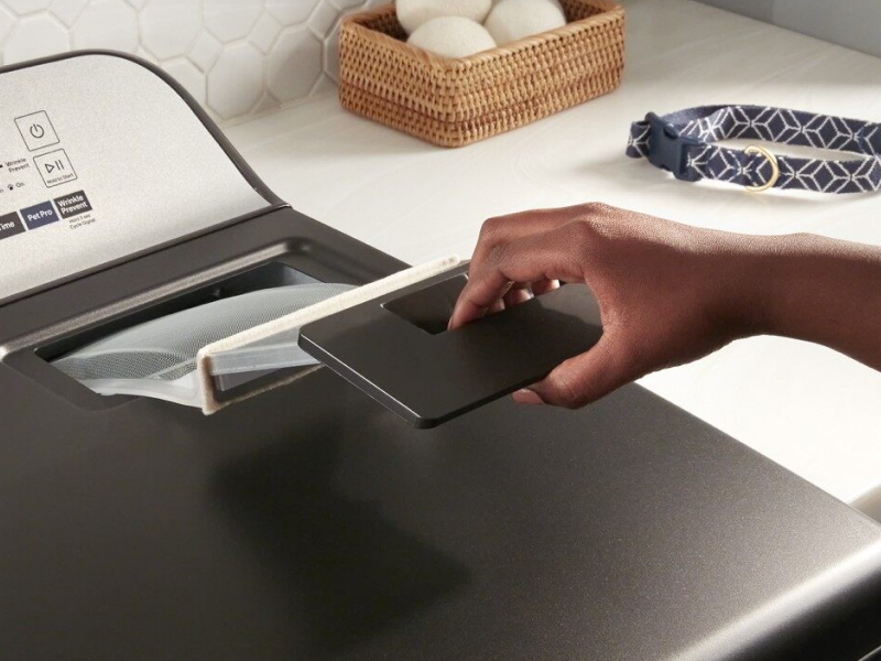 Person remove lint trap from front load dryer Person remove lint trap from front load dryer