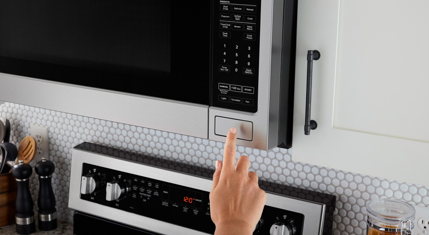 A finger making a selection on a Maytag® microwave A finger making a selection on a Maytag® microwave