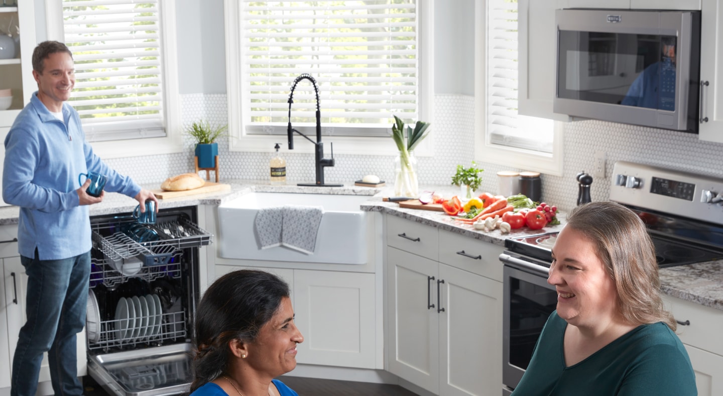 A kitchen filled with smiling people A kitchen filled with smiling people