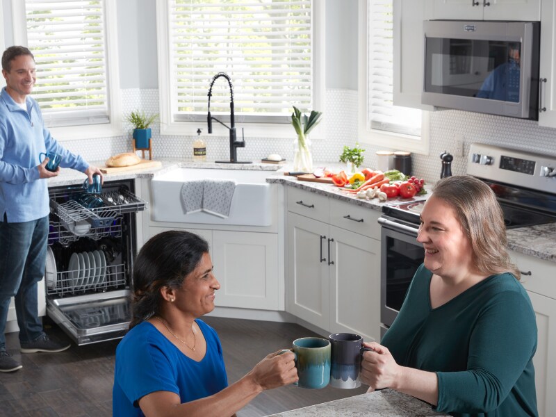 A kitchen filled with smiling people A kitchen filled with smiling people