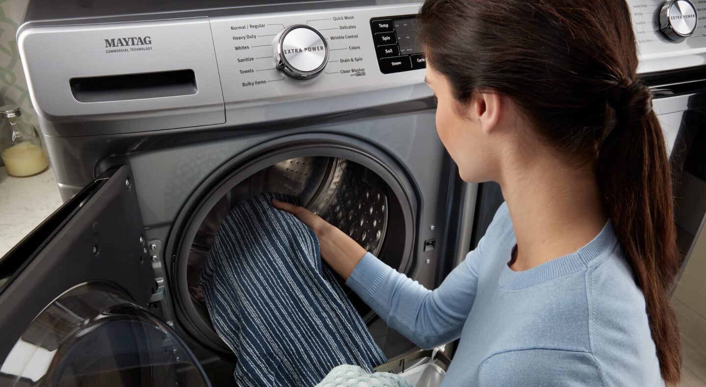 Person removing clothing from a washing machine