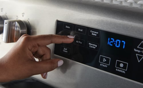 Person selecting a setting on a Maytag® range