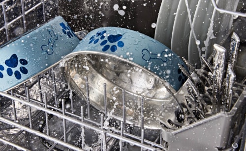 Close-up of a dog food and water bowl washing in the bottom rack of a dishwasher