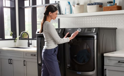 Person selecting a drying cycle on a Maytag® dryer