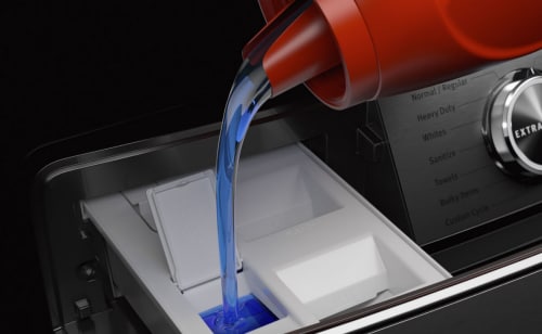 A closeup of liquid laundry detergent being poured into a Maytag® washer dispenser