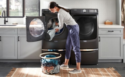 Person doing laundry with a Maytag® washing machine