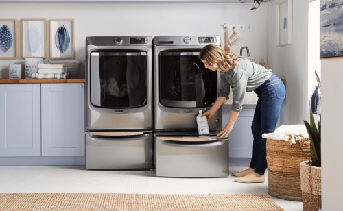 A person putting Swash® detergent inside a laundry pedestal