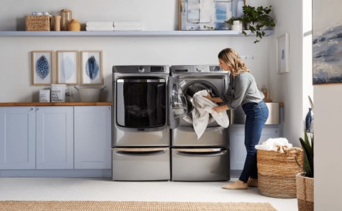 A person taking laundry out of a Maytag® dryer