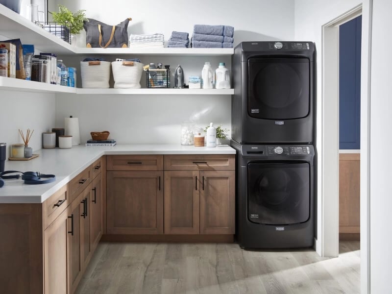 Stacked black Maytag® front load washer and dryer pair in laundry room