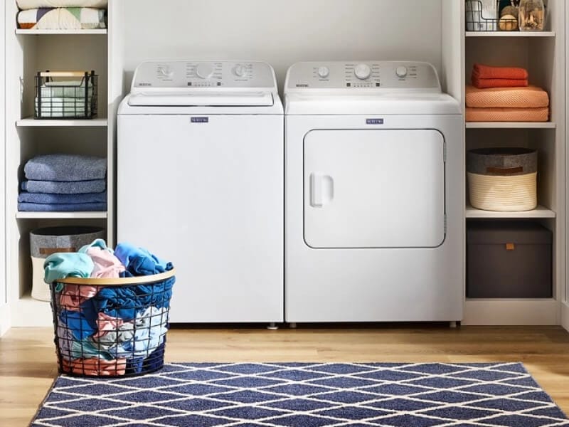White Maytag® front load laundry pair between shelving in a laundry room